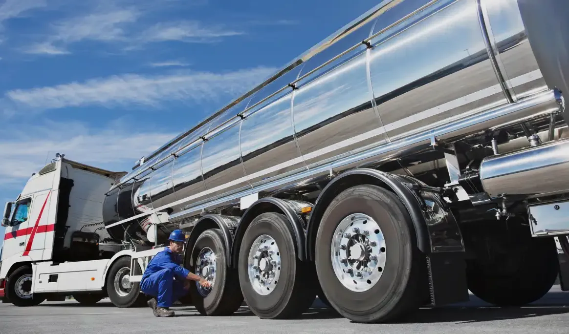 Camion-citerne et conducteur effectuant une vérification avant départ